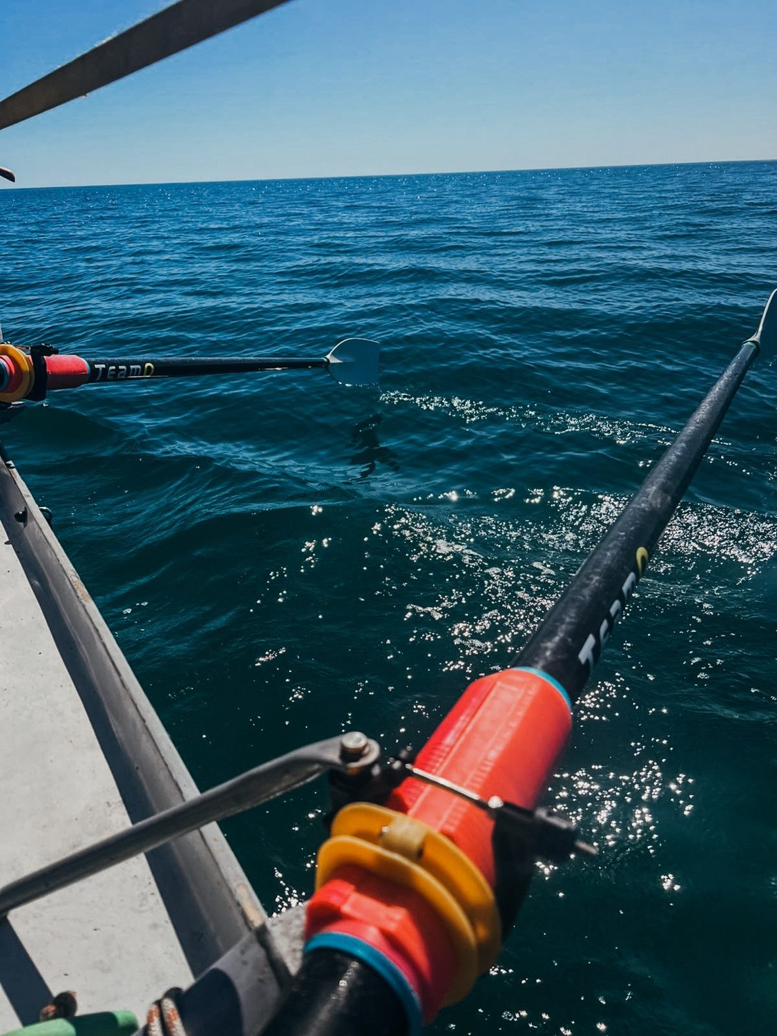 Bow of the ocean rowing boat cutting through deep blue water