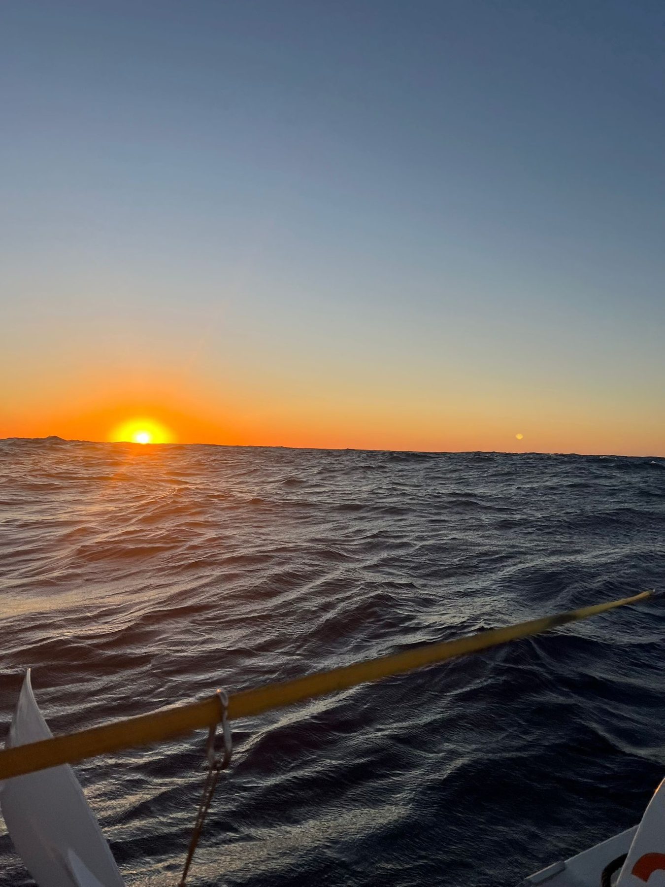Sunset over the open ocean from the bow of an ocean rowing boat